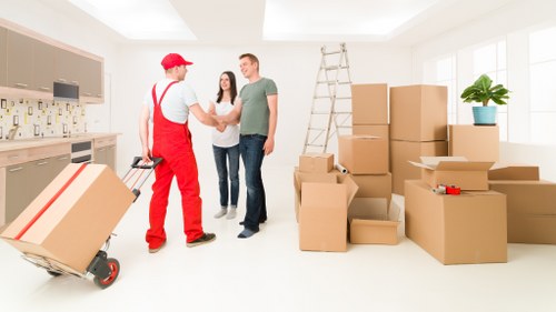 Mover wearing PPE handling boxes during a safe removal job